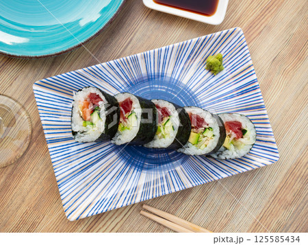 Set of japanese rolls futomaki with soy and chili sauces close up Set of japanese rolls futomaki with soy and chili sauces close up 125585434
