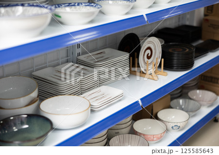 Shelves with various noodle bowls and plates in Asian store 125585643