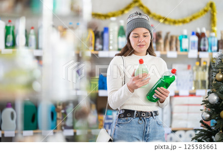 On New Year Eve, girl choose and buy dishwashing detergent On New Year Eve, girl choose and buy dishwashing detergent 125585661