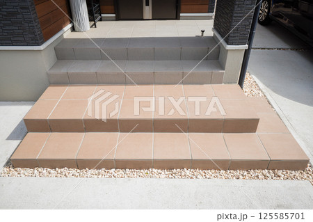 住宅イメージ　玄関アプローチ　貼り替えた階段の茶色いタイル 125585701