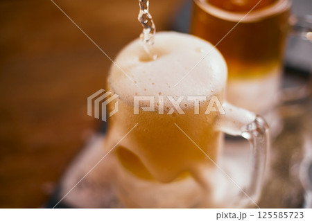 mug of beer on wooden table 125585723