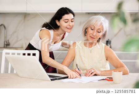 Mature woman meeting financial advisor for investment at home Mature woman meeting financial advisor for investment at home 125585781