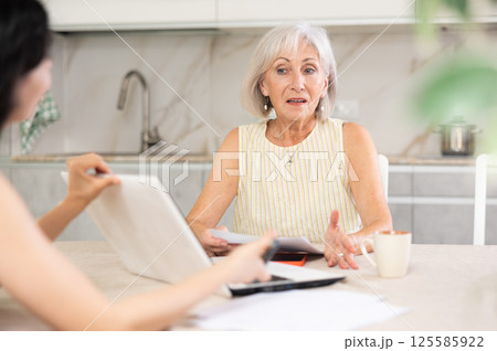 Mature woman meeting financial advisor for investment at home 125585922