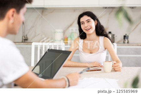 Young woman discussing deal with salesman in kitchen 125585969