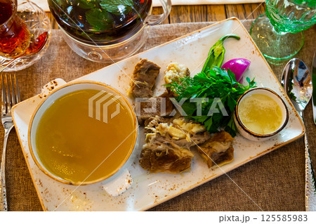 Georgian Khashlama, boiled lamb meat with broth and greens 125585983