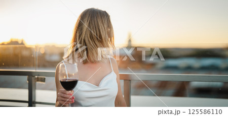 Beautiful woman with a glass of red wine on the terrace Beautiful woman with a glass of red wine on the terrace 125586110