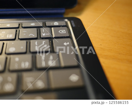 テーブルに置かれたスマートフォン　パソコンのキーボードとリモコン　コピースペース　自宅の何気ない景色 125586155