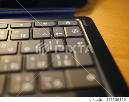 テーブルに置かれたスマートフォン　パソコンのキーボードとリモコン　コピースペース　自宅の何気ない景色 125586156