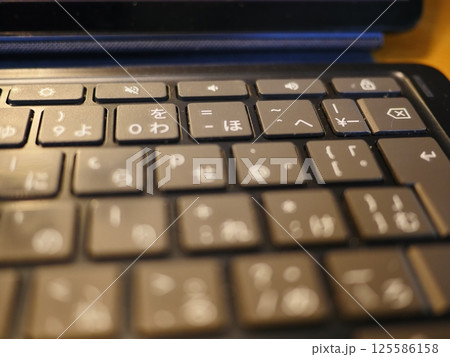 テーブルに置かれたスマートフォン　パソコンのキーボードとリモコン　コピースペース　自宅の何気ない景色 125586158