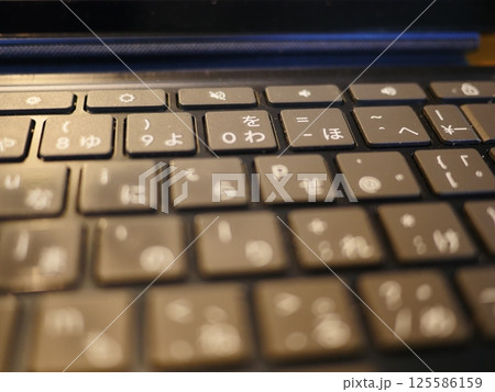 テーブルに置かれたスマートフォン　パソコンのキーボードとリモコン　コピースペース　自宅の何気ない景色 125586159