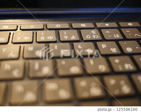 テーブルに置かれたスマートフォン　パソコンのキーボードとリモコン　コピースペース　自宅の何気ない景色 125586160