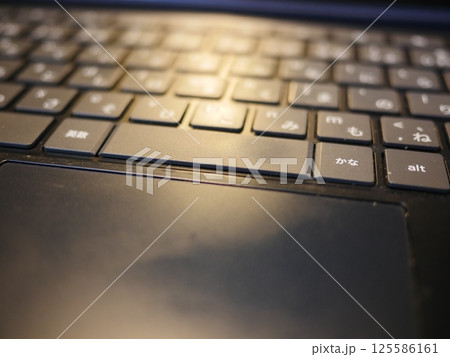 テーブルに置かれたスマートフォン　パソコンのキーボードとリモコン　コピースペース　自宅の何気ない景色 125586161