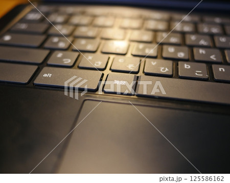 テーブルに置かれたスマートフォン　パソコンのキーボードとリモコン　コピースペース　自宅の何気ない景色 125586162