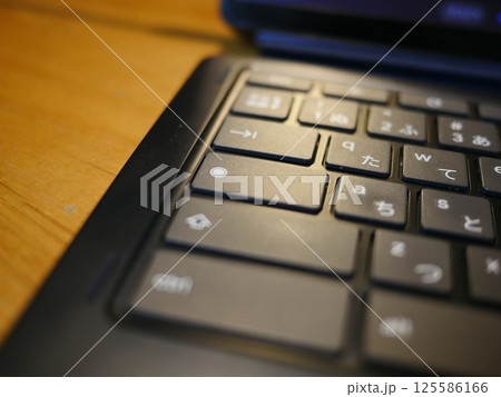 テーブルに置かれたスマートフォン　パソコンのキーボードとリモコン　コピースペース　自宅の何気ない景色 125586166