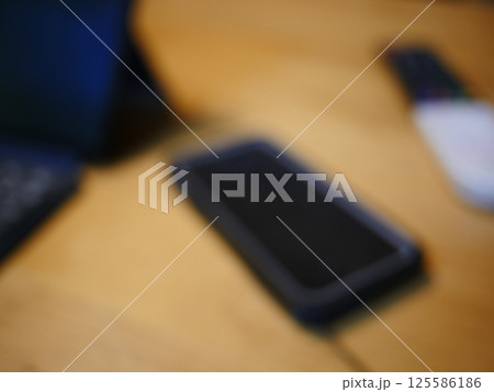 テーブルに置かれたスマートフォン パソコンのキーボードとリモコン コピースペース 自宅の何気ない景色 テーブルに置かれたスマートフォン パソコンのキーボードとリモコン コピースペース 自宅の何気ない景色 125586186
