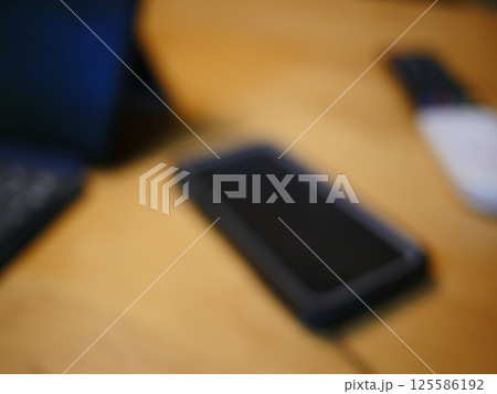 テーブルに置かれたスマートフォン パソコンのキーボードとリモコン コピースペース 自宅の何気ない景色 テーブルに置かれたスマートフォン パソコンのキーボードとリモコン コピースペース 自宅の何気ない景色 125586192