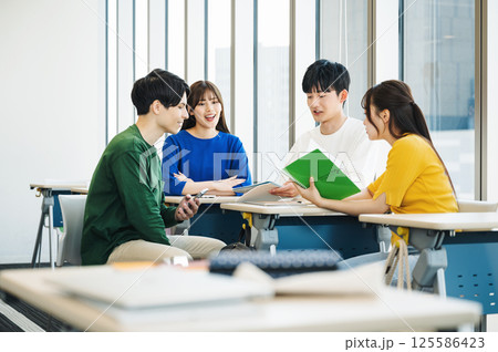 学校の教室で休み時間に話す男女学生 125586423