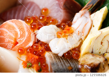 Donburi with sliced of fresh raw seafood and grilled fish on sushi rice in paper container. Healthy take away food. Donburi with sliced of fresh raw seafood and grilled fish on sushi rice in paper container. Healthy take away food. 125586826