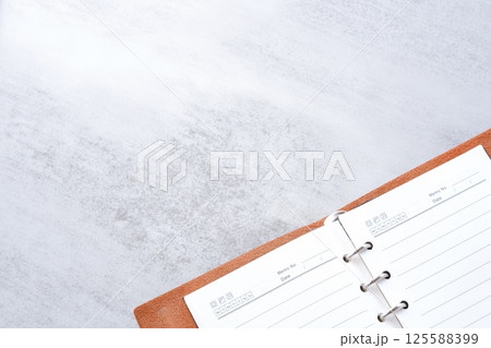 リング式のシステム手帳を開いてデスクワークをしているイメージ リング式のシステム手帳を開いてデスクワークをしているイメージ 125588399
