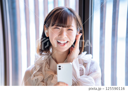 スマホで音楽を聴く若い女性 125590116