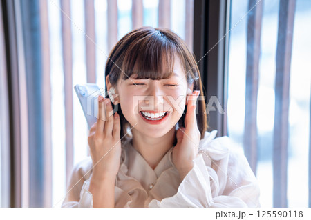 スマホで音楽を聴く若い女性 125590118