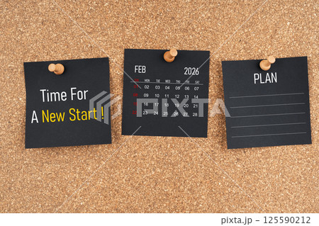 February 2026 calendar with Time for a new start and Plan text on black adhesive notes with wooden. 125590212