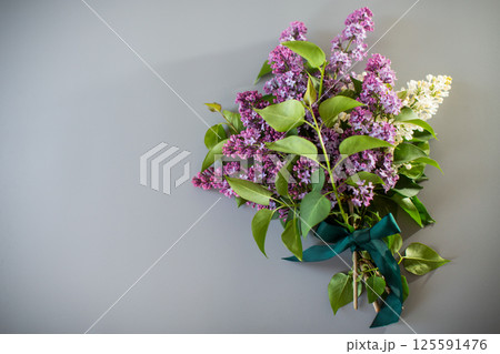 Bouquet of white and purple lilacs on a gray background 125591476