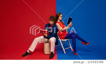 Couple reading books back to back showing focus and independence 125591599
