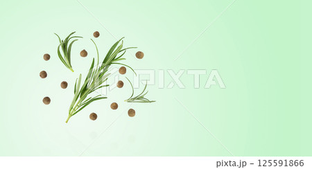 Spices rosemary sprigs and black pepper peas on a green background. Concept of healthy eating, cooking Spices rosemary sprigs and black pepper peas on a green background. Concept of healthy eating, cooking 125591866