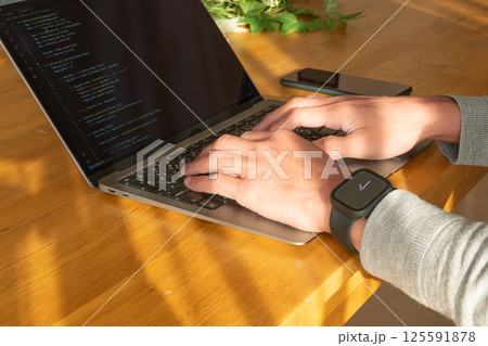 ノートパソコンで作業をする男性の手元 125591878