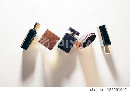 minimalist perfume bottle composition casting soft shadows on white background in studio, top view of luxury fragrance packaging design, cosmetics brand, fashion, beauty industry 125591945