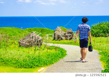 宮古島の有名観光地で南国バカンス・東平安名埼の崖や道から覗く青い海と観光する男性(沖縄県宮古島市) 宮古島の有名観光地で南国バカンス・東平安名埼の崖や道から覗く青い海と観光する男性(沖縄県宮古島市) 125592521