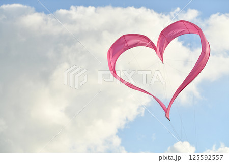Pink heart kite is flying in the wind 125592557