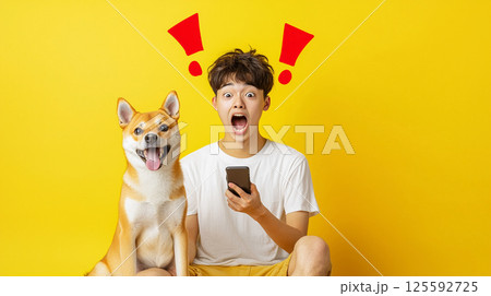 スマホを見て驚く少年と柴犬 125592725