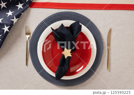 Table setting for USA Independence Day. Festive dinner with red plate and decoration in USA national flag colors white, red and blue. View from above. Copy space. Close up. Table setting for USA Independence Day. Festive dinner with red plate and decoration in USA national flag colors white, red and blue. View from above. Copy space. Close up. 125593225