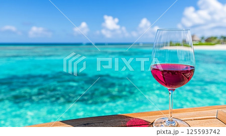 Couple enjoys red wine on yacht in sparkling turquoise water under a clear blue sky 125593742