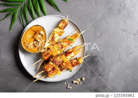Grilled tofu and pineapple satay skewers and peanut spicy sauce Grilled tofu and pineapple satay skewers and peanut spicy sauce 125593961