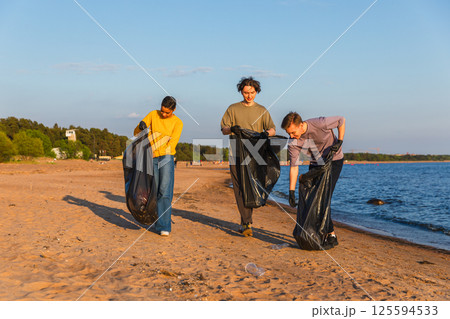 Earth day. Volunteers activists team collects garbage cleaning of beach coastal zone. Woman mans with trash in garbage bag on ocean shore. Environmental conservation coastal zone cleaning Earth day. Volunteers activists team collects garbage cleaning of beach coastal zone. Woman mans with trash in garbage bag on ocean shore. Environmental conservation coastal zone cleaning 125594533