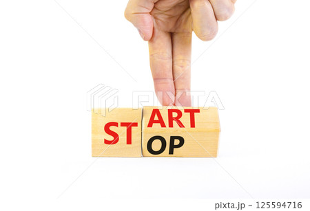 Start or stop symbol. Concept words Start or Stop on beautiful wooden block. Beautiful white table white background. Businessman hand. Business start or stop concept. Copy space. 125594716