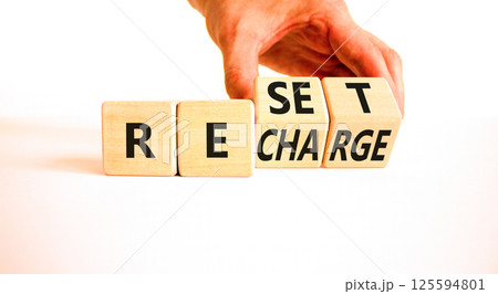 Reset and recharge symbol. Concept words Reset Recharge on beautiful wooden block. Beautiful white table white background. Businessman hand. Business reset and recharge concept. Copy space. Reset and recharge symbol. Concept words Reset Recharge on beautiful wooden block. Beautiful white table white background. Businessman hand. Business reset and recharge concept. Copy space. 125594801