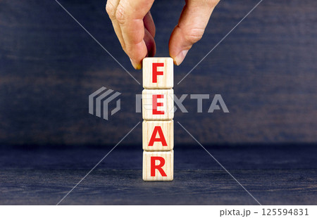 Fear symbol. Concept word Fear on beautiful wooden blocks. Businessman hand. Beautiful black table black background. Business, lifestyle and fear concept. Copy space. 125594831