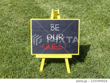 Be our guest symbol. Concept words Be our guest on beautiful yellow blackboard. Beautiful green grass lawn background. Business and be our guest concept. Copy space. Be our guest symbol. Concept words Be our guest on beautiful yellow blackboard. Beautiful green grass lawn background. Business and be our guest concept. Copy space. 125594928
