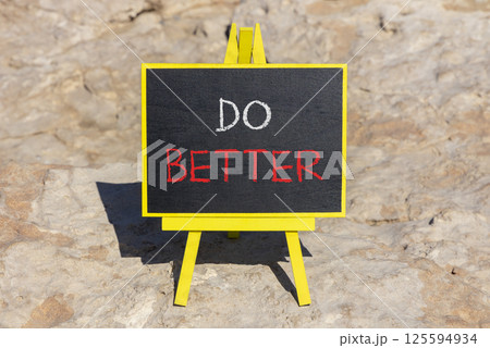 Do better symbol. Concept words Do better on beautiful yellow chalk blackboard. Beautiful stone beach background. Business and do better concept. Copy space. 125594934