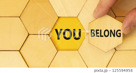 Belonging and you belong symbol. Concept words You belong on beautiful wooden puzzle. Beautiful wooden background. Businessman hand. Business belonging and you belong concept. Copy space. Belonging and you belong symbol. Concept words You belong on beautiful wooden puzzle. Beautiful wooden background. Businessman hand. Business belonging and you belong concept. Copy space. 125594958