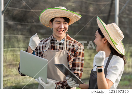 Innovative Gardening Couple Embraces Technology for Successful Modern Farming Practices in a Greenhouse Setting 125597390