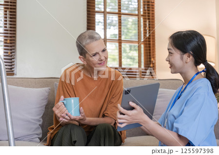 Young Nurse Offering Health Care Advice to Elderly Woman in a Cozy Home Setting, Promoting Wellness and Supportive Care for Seniors 125597398