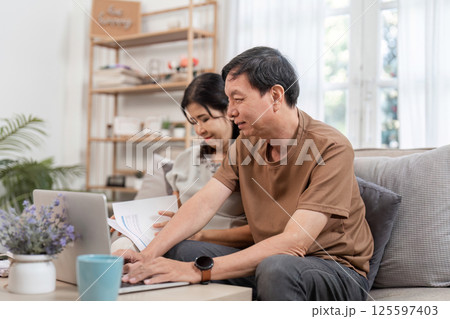 Elderly Couple Managing Family Finances Together at Home with Laptop and Documents Elderly Couple Managing Family Finances Together at Home with Laptop and Documents 125597403