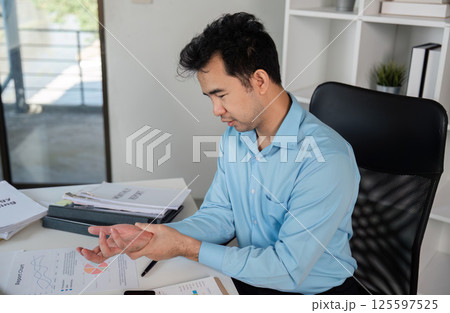 Office Worker Experiencing Muscle Pain and Discomfort Due to Office Syndrome in a Modern Workplace Environment 125597525