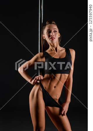 Woman performing sensual dance routine at a pole dancing studio Woman performing sensual dance routine at a pole dancing studio 125597940