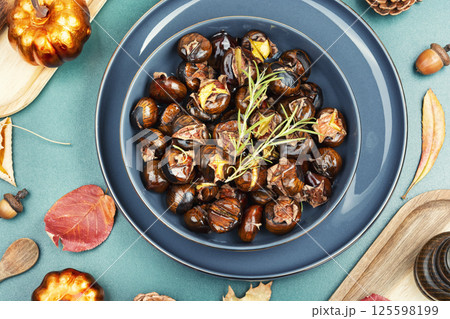 Warm roasted chestnuts served on a plate Warm roasted chestnuts served on a plate 125598199